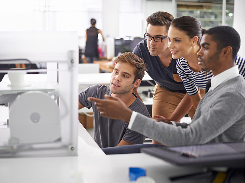 Team of office employees collaborating on computer screen.