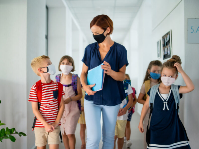 Teacher and her classroom walking down a hall.