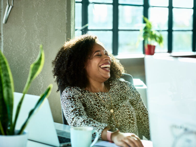 Professional woman laughing and looking happy.