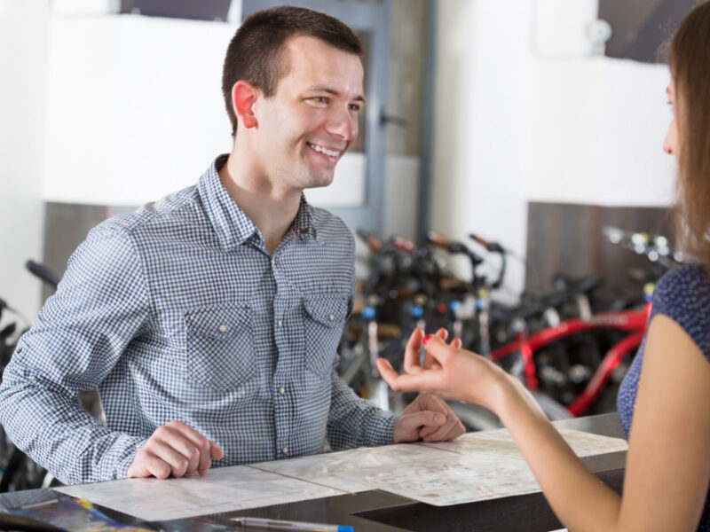 Employee speaking to customer at bike shop.