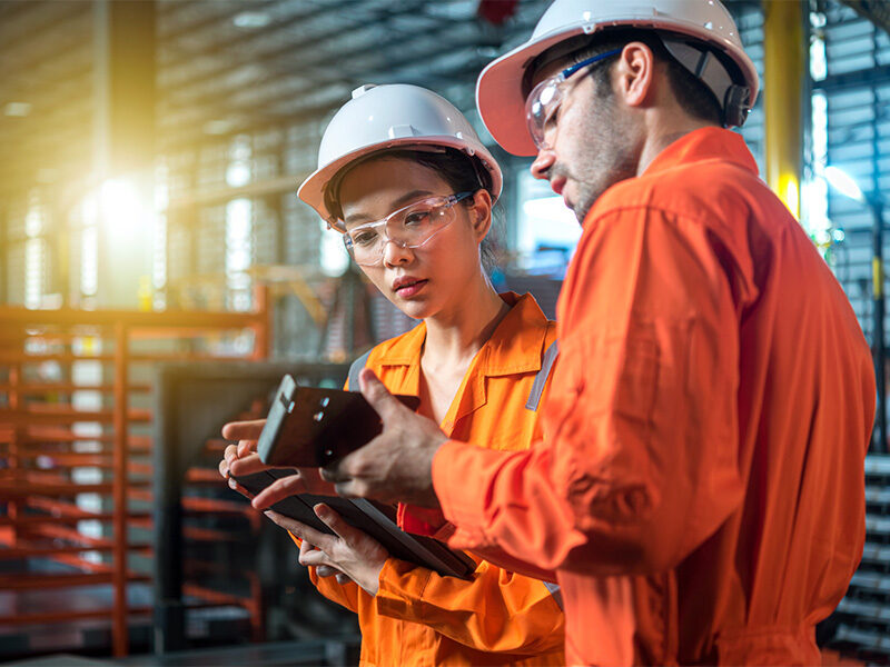 Male and Female engineer are checking quality of product on hand. Male Engineer explain his investigate result.