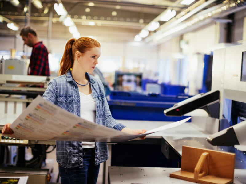 young woman working at a digital printer.