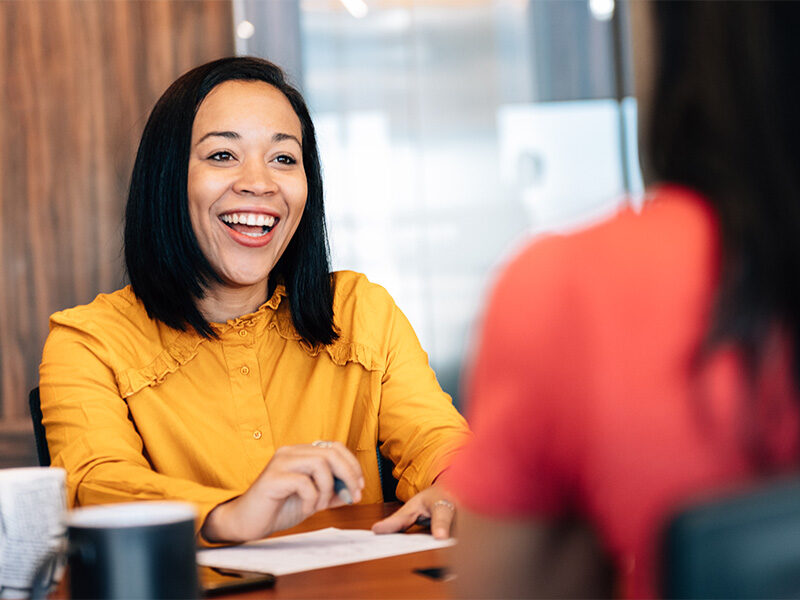 Happy smiling woman in the office having a conversation.