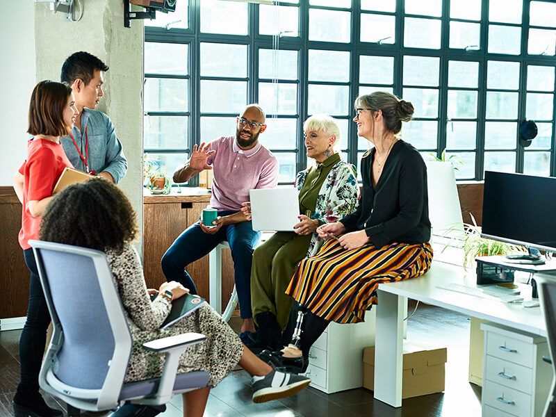 Diverse Group talking smiling in the office.