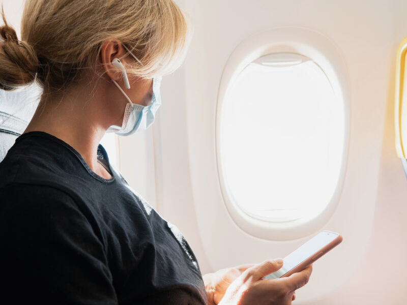 Woman wearing prevention mask during a flight inside an airplane