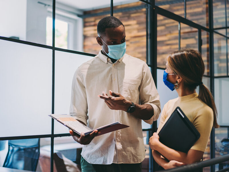 Business people wearing protective face masks at work during COVID-19 pandemic